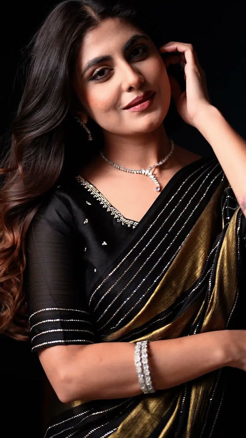 Black and golden designer saree with shimmering stripes and an embellished border